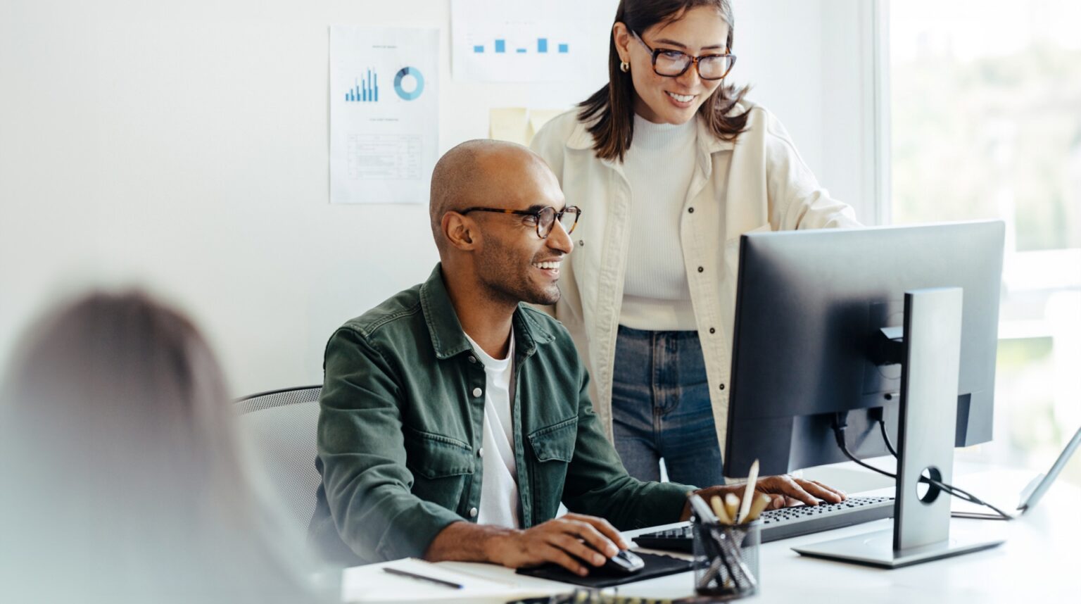 Computerprogrammierer bei der Überprüfung von Daten im Büro, stellvertretend für die Partnerschaft von GlobalLogic, Hitachi und Google Cloud zur Beschleunigung der Unternehmensinnovation und -produktivität durch generative KI-Lösungen für Softwaremodernisierung und hybride Cloud-Umgebungen.