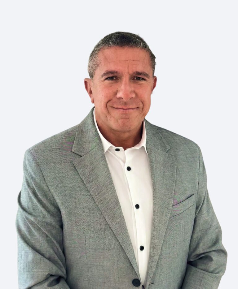 Professional head-and-shoulders portrait of a man in a light gray suit and white shirt, smiling subtly.