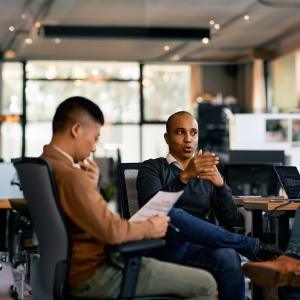 Traja sebavedomí programátori diskutujú o projekte, stojac pri počítači v kancelárii v noci, čo symbolizuje spoluprácu a inovácie prostredníctvom služieb Microsoft Azure na transformáciu podnikov a špecifických priemyselných riešení.[WU1] [A2]