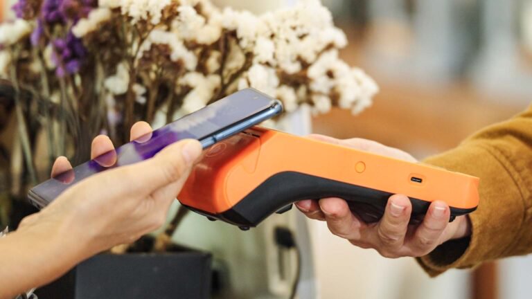 Customer making a contactless mobile payment at a retail store, representing enterprise AI financial services innovation in electronic payment systems and banking technology.
