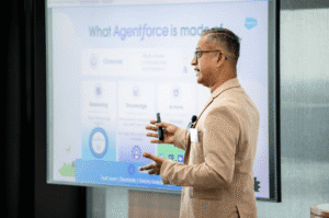 A man standing in front of a large screen, giving a presentation on Agentforce.
