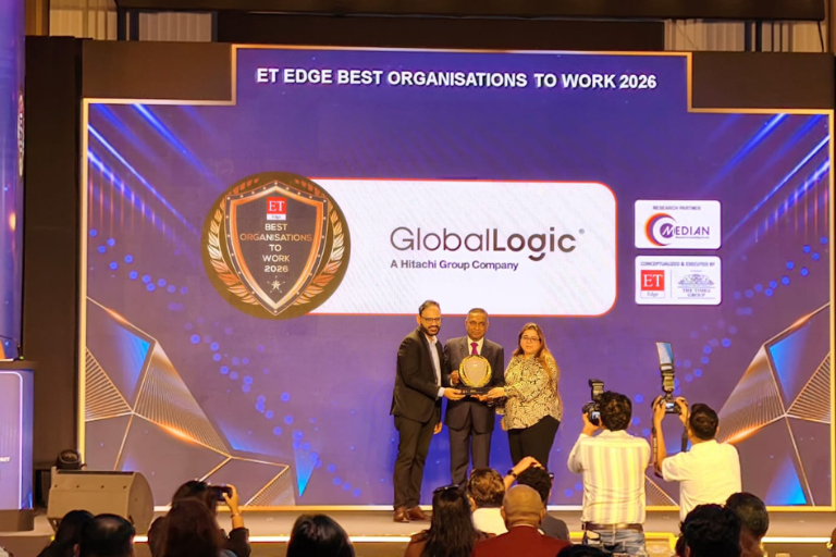 2 - GlobalLogic Three people on stage receive a trophy at an awards ceremony, with a blue backdrop showing ET Edge Best Organisations to Work 2026 and the GlobalLogic logo behind them.